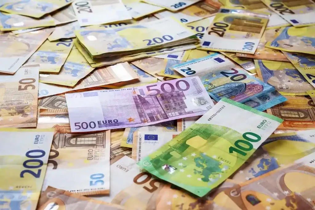 Billets d'euros éparpillés illustrant les plafonds de retrait au distributeur
